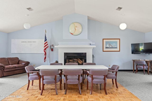 dining space with vaulted ceiling, a fireplace, baseboards, and visible vents