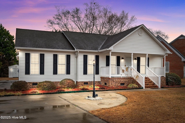 view of front of home featuring a storage unit and covered porch