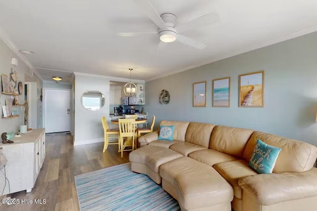 living room featuring ceiling fan, ornamental molding, and wood-type flooring