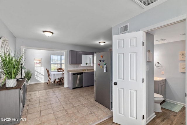 kitchen featuring stainless steel appliances and gray cabinetry