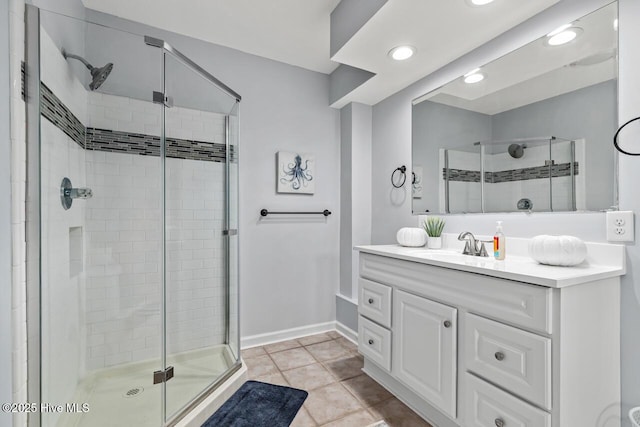 bathroom featuring a shower with door, vanity, and tile patterned flooring