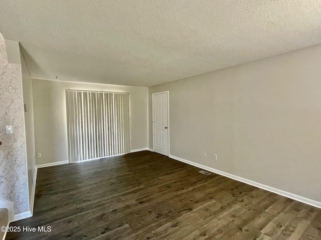 unfurnished room featuring dark hardwood / wood-style flooring and a textured ceiling