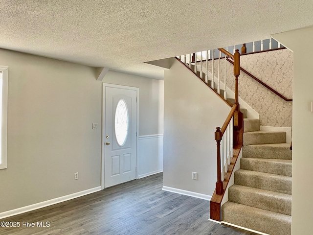 entryway with dark hardwood / wood-style floors and a textured ceiling