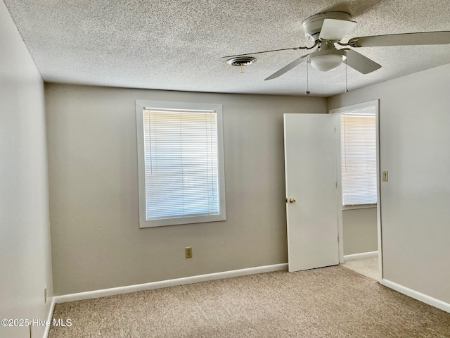 carpeted spare room with ceiling fan and a textured ceiling