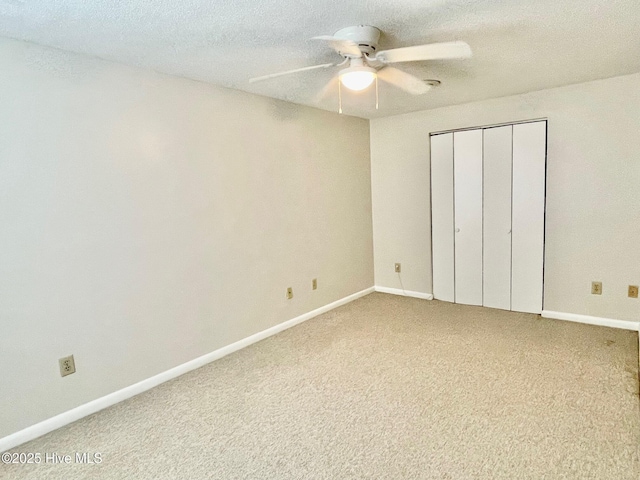 unfurnished bedroom with ceiling fan, a closet, a textured ceiling, and carpet flooring