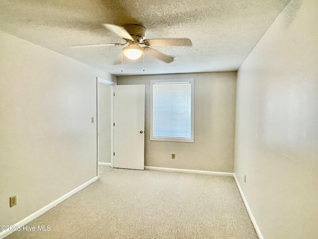 carpeted empty room with ceiling fan and a textured ceiling