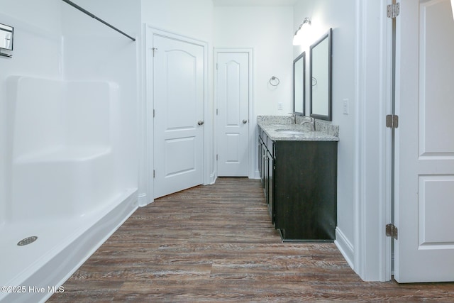 bathroom featuring vanity, wood-type flooring, and a shower