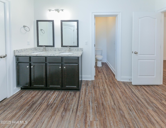 bathroom with hardwood / wood-style flooring, vanity, and toilet