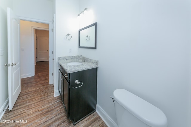 bathroom featuring vanity, hardwood / wood-style floors, and toilet