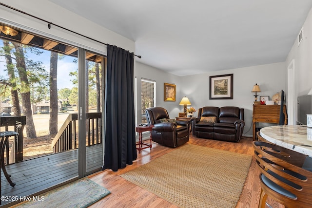 living area with visible vents and wood finished floors