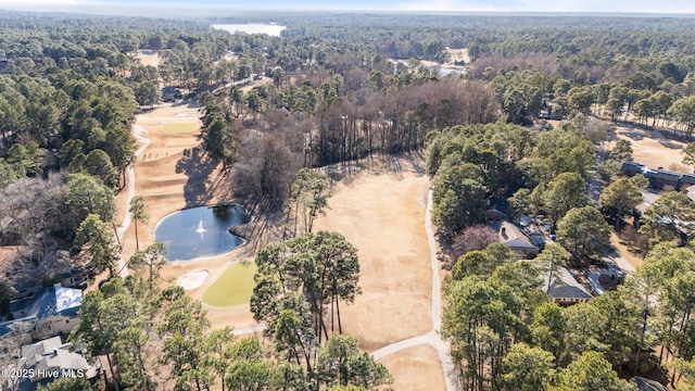 birds eye view of property featuring a water view and a wooded view