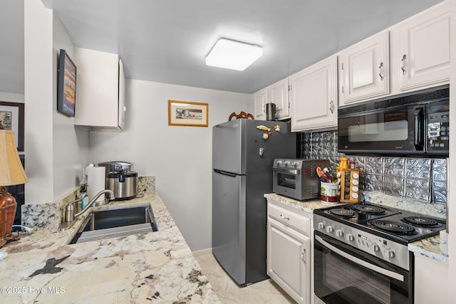 kitchen with a toaster, decorative backsplash, appliances with stainless steel finishes, white cabinetry, and a sink