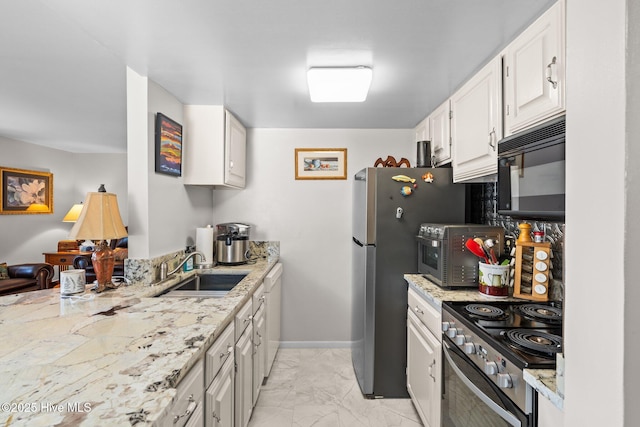 kitchen with baseboards, marble finish floor, stainless steel appliances, white cabinetry, and a sink