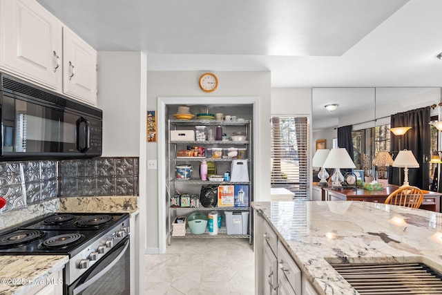 kitchen with black microwave, light stone counters, white cabinetry, marble finish floor, and stainless steel range with electric stovetop