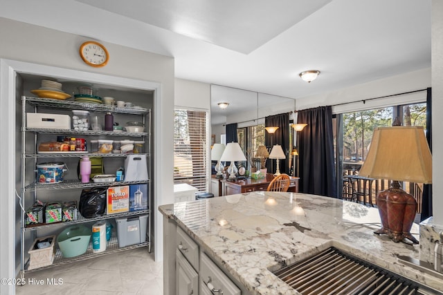 kitchen featuring pendant lighting, marble finish floor, white cabinets, and light stone countertops