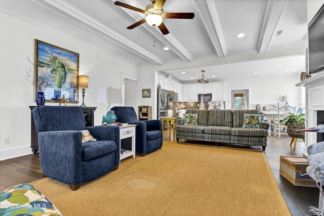 living room featuring beamed ceiling, ornamental molding, hardwood / wood-style flooring, and ceiling fan