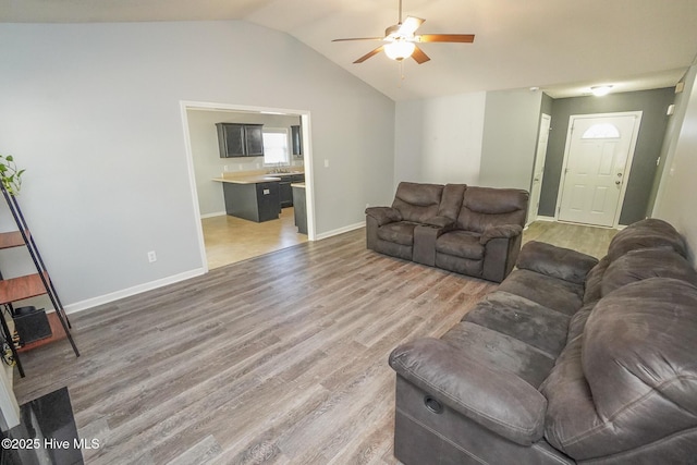 living room featuring wood-type flooring, vaulted ceiling, and ceiling fan