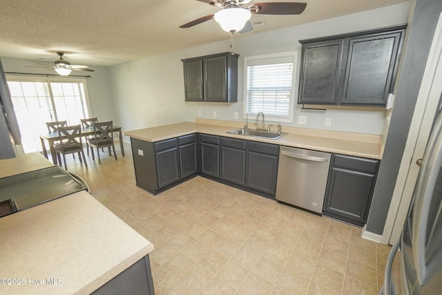 kitchen with sink, plenty of natural light, stainless steel dishwasher, and a textured ceiling