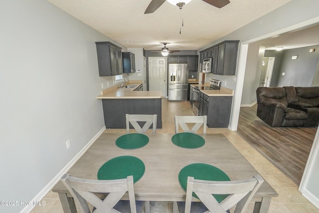 dining space with sink, a textured ceiling, and light wood-type flooring