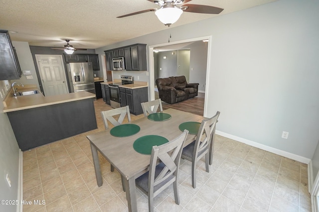 dining space featuring sink, a textured ceiling, and ceiling fan