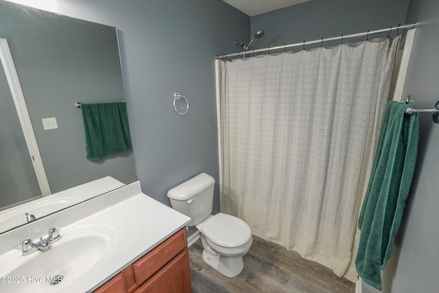 bathroom featuring wood-type flooring, a shower with shower curtain, vanity, and toilet