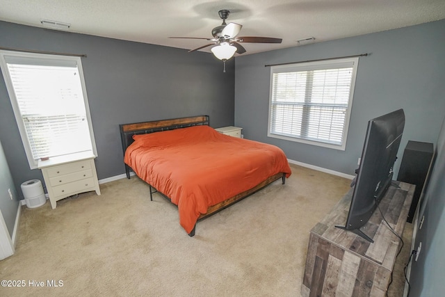 bedroom featuring light carpet, a textured ceiling, and ceiling fan