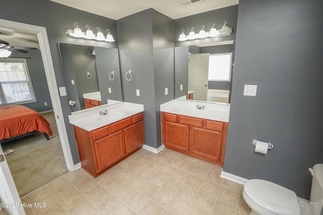 bathroom featuring ceiling fan, vanity, toilet, and tile patterned floors