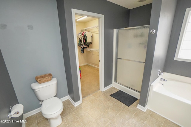 bathroom with tile patterned floors, toilet, and separate shower and tub