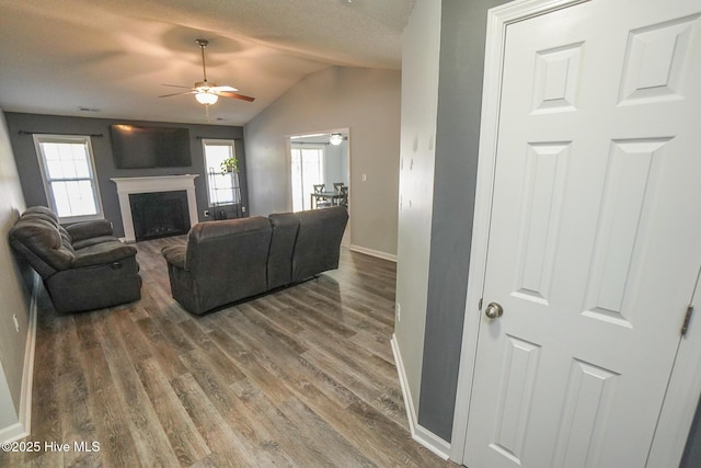 living room with hardwood / wood-style flooring, vaulted ceiling, a wealth of natural light, and ceiling fan