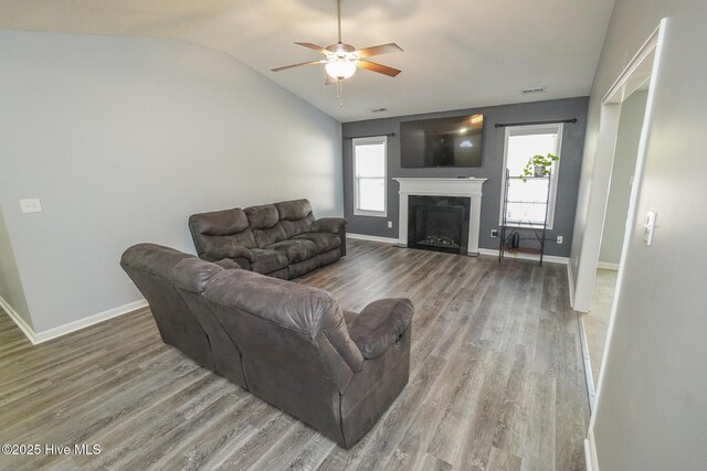 living room with lofted ceiling, ceiling fan, a wealth of natural light, and wood-type flooring