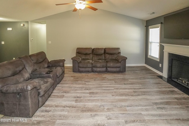 living room with lofted ceiling, light hardwood / wood-style floors, and ceiling fan