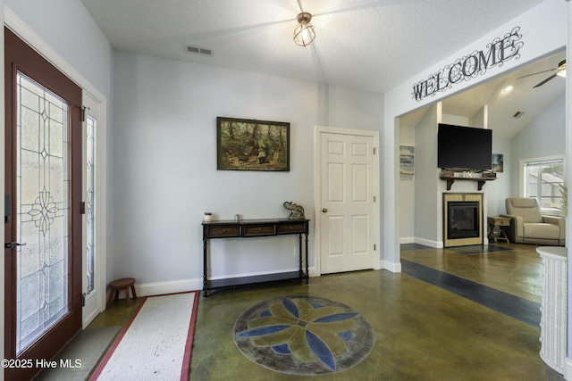 foyer entrance with vaulted ceiling and a textured ceiling