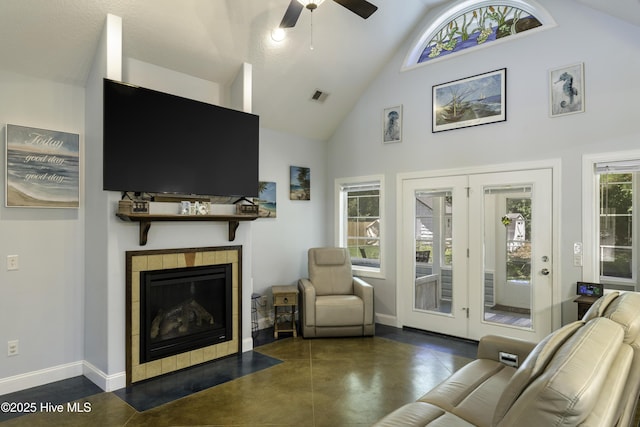 living room with french doors, ceiling fan, high vaulted ceiling, and a tile fireplace