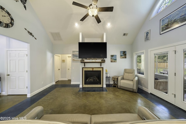 living room with a tiled fireplace, high vaulted ceiling, and ceiling fan