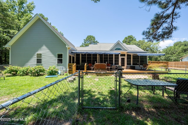 back of property with a wooden deck and a yard