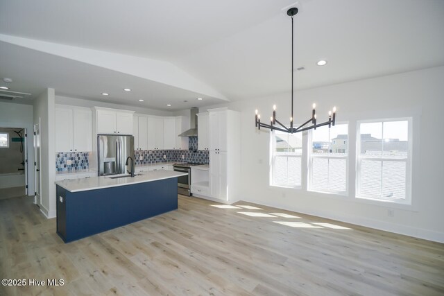 5228 E Beach Dr, Oak Island, NC 28465 - kitchen with a sink, stainless steel appliances, wall chimney range hood, decorative backsplash, and an inviting chandelier