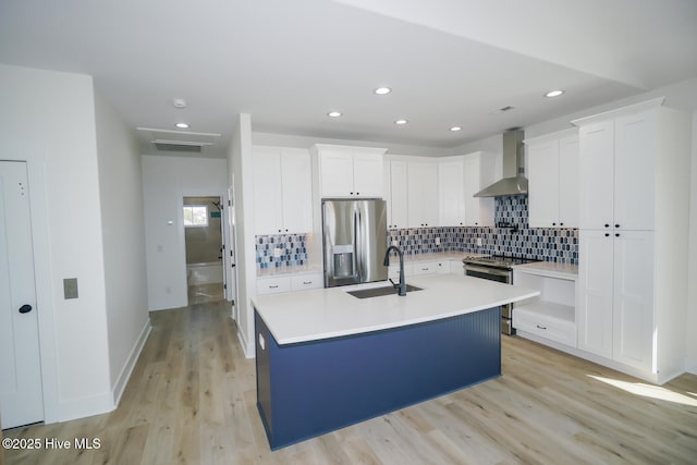 5228 E Beach Dr, Oak Island, NC 28465 - kitchen featuring a sink, wall chimney range hood, stainless steel appliances, and light wood-style floors
