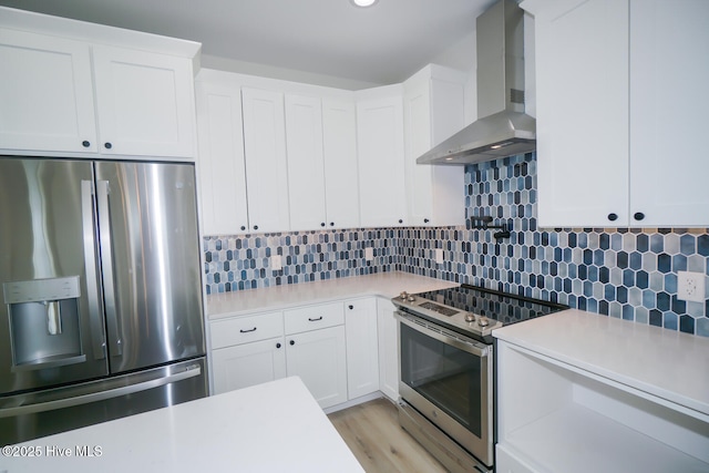 5228 E Beach Dr, Oak Island, NC 28465 - kitchen with white cabinetry, light countertops, stainless steel appliances, backsplash, and wall chimney exhaust hood