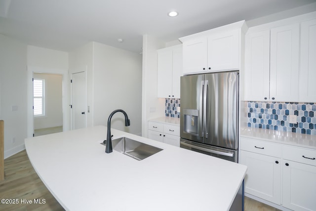 5228 E Beach Dr, Oak Island, NC 28465 - kitchen with a kitchen island with sink, decorative backsplash, a sink, and stainless steel refrigerator with ice dispenser