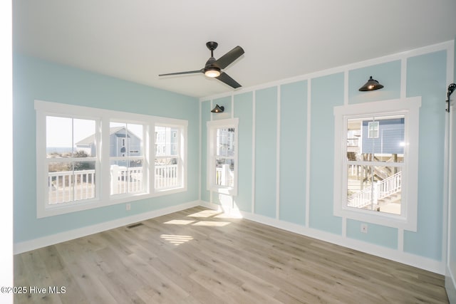 5228 E Beach Dr, Oak Island, NC 28465 - spare room featuring a ceiling fan, visible vents, and wood finished floors