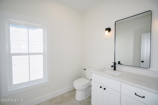 5228 E Beach Dr, Oak Island, NC 28465 - bathroom featuring baseboards, toilet, vanity, and a healthy amount of sunlight