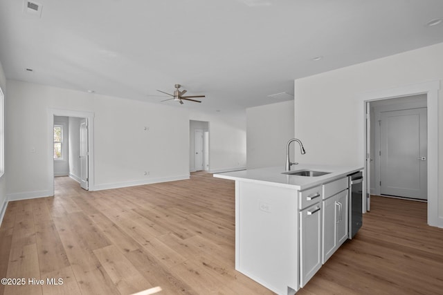 kitchen with sink, white cabinetry, light hardwood / wood-style flooring, dishwasher, and an island with sink