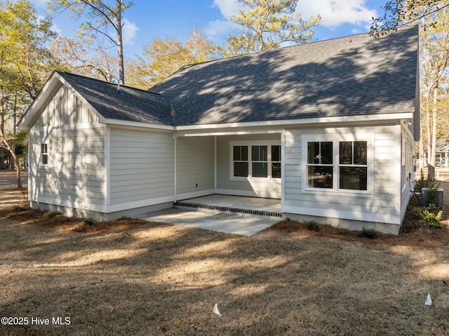 rear view of property with a yard, central AC unit, and a patio