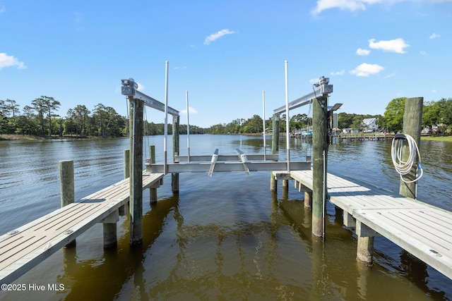 dock area with boat lift and a water view