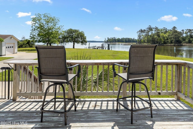 wooden terrace featuring a water view and a lawn
