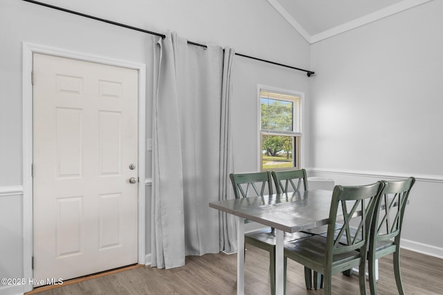 dining area with vaulted ceiling and wood finished floors