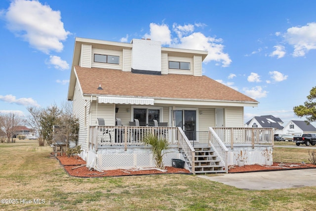 view of front of property with a porch, roof with shingles, and a front yard