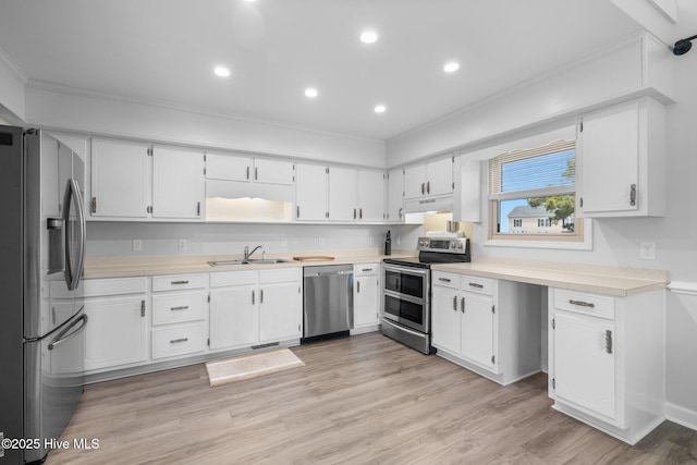 kitchen featuring stainless steel appliances, under cabinet range hood, a sink, crown molding, and light countertops