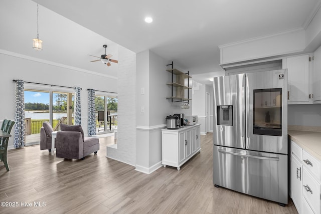kitchen with stainless steel refrigerator with ice dispenser, light countertops, a ceiling fan, white cabinetry, and light wood finished floors