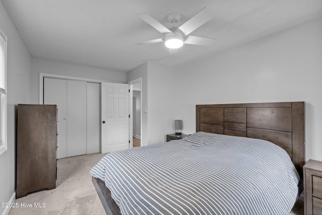 bedroom with light carpet, a closet, and a ceiling fan